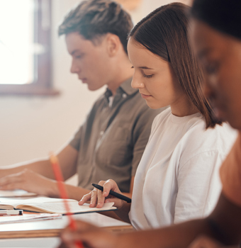 Two female and one male student taking a test.