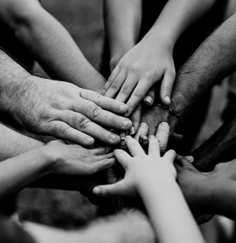 A group of people holding hands in black and white.