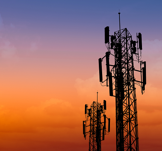 Cellular transmitter towers against the background of the evening sky.