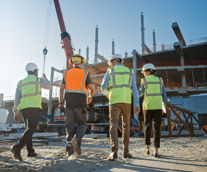 Construction Team Inspect Building Construction Project. In the Background Crane, Skyscraper Formwork Frames