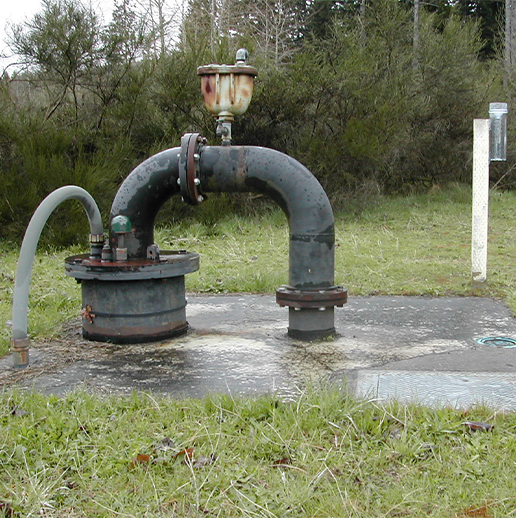 Picture of well piping on concrete pad.