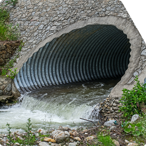 Water discharging from large diameter drainage pipes.