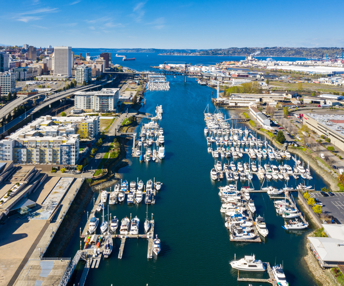 Foss Waterway and Tacoma Skyline. Along the waterway are condominiums and boat docks with a marina.