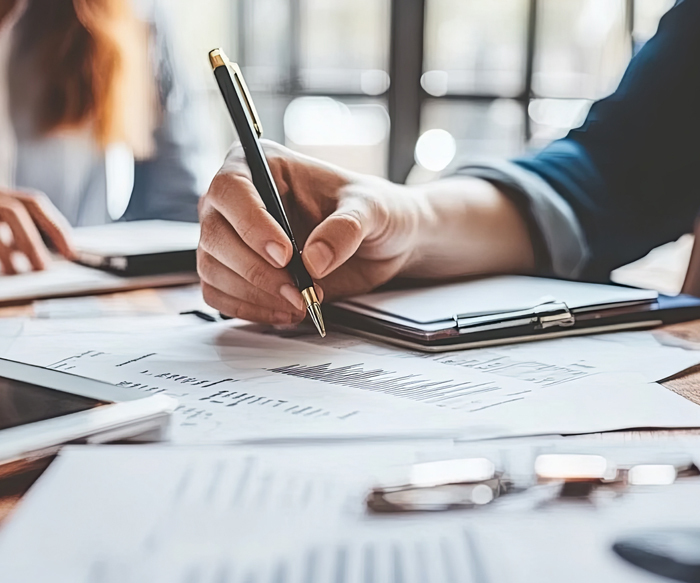 Group of attorneys showing hands, one with a pen writing on a document