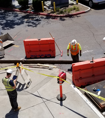 Aerial image looking down on construction site with worker taking notes.