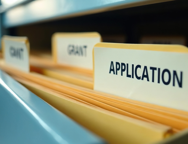 File cabinet with file folders labelled Application and Grant